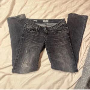 Grå jeans med slitningar - Snygga grå jeans med slitningar och en trasig detalj på ena benet. De har en klassisk femficksdesign och en bekväm passform. Perfekta för en avslappnad stil. Lite slitna där nere som syns på bild 29/34💕