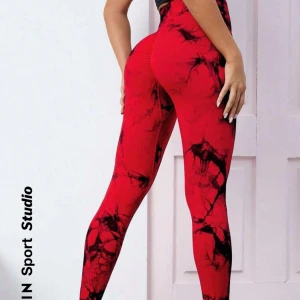 Röda leggings med mönster - Snygga röda leggings med ett coolt svart mönster. Perfekta för träning eller en avslappnad dag. De har en tight passform som framhäver figuren.