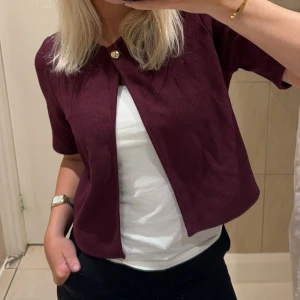 Vinröd kortärmad kofta - Säljer denna fina kofta från Gina då jag inte får användning för den, använd endast en gång. 