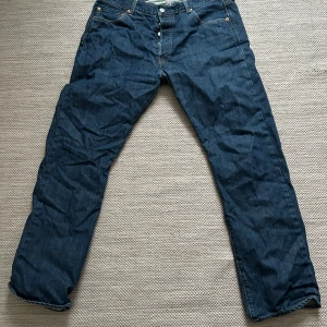 Levi's 501 jeans - Säljer ett par klassiska Levi's 501 jeans i blå denim. W36/L32, de har en straight passform och är i bra skick. Perfekta för både vardag och fest!