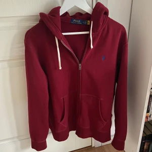 Ralph lauren zip hoodie - Säljer en tvärsnygg Ralph lauren zip hoodie! Den vinröda färgen är perfekt nu till vintern. Skick 9,5/10, använd väldigt få gånger. Nypris 2000kr, mitt pris endast 699kr! Hör av er vid funderingar.