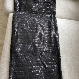 Svart paljettklänning från Stylein - Snygg svart klänning från Stylein i storlek S. Längd 71 cm. Klänningen är täckt med glittriga paljetter som ger en festlig look. Perfekt för en utekväll eller nyårsfest! ✨