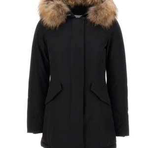 Svart parkajacka med pälsdetalj - Snygg svart parkajacka med en fluffig pälsdetalj på huvan. Perfekt för kalla vinterdagar. Jackan har långa ärmar och praktiska fickor framtill. Den är både stilren och funktionell, vilket gör den till ett måste i garderoben.