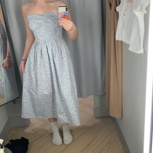 Blommig sommarklänning med smala axelband - Säljer en superfin blommig klänning i ljusblått med smala axelband, köpt för 300kr på hm och säljer för 120kr Pris går att diskutera!!! använd 1 gång