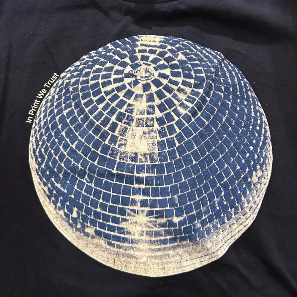 Säljer en svart t-shirt från In Print We Trust i bomull med ett coolt discokultryck på framsidan. Perfekt för en avslappnad stil eller en utekväll. T-shirten har korta ärmar och en normal passform. Texten 'In Print We Trust' finns tryckt bredvid discokulan.. T-paidat.