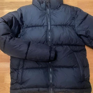 Svart vinterjacka från Everest - Säljer en snygg och varm svart vinterjacka från Everest i storlek XXS. Perfekt för kalla vinterdagar med sin pufferstil och dragkedja framtill. Jackan är använd en vinter och är i bra skick. 