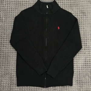 Ralph Lauren full zip - Jättesnygg stickad Ralph lauren zip. 20% Ull, 70% Bomull, 10% Nylon. Så denna kommer hålla dig mycket varm under vintern. Säljer pga att den är för liten. Storleken är L men den sitter lite tajtare så har du L vanligtvis kommer den nog sitta lite tajtare och har du M kommer den ha en lite mer vanlig passform