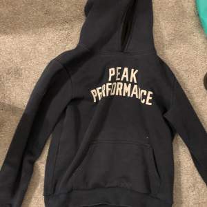 Säljer en svart hoodie från Peak Performance i bra skick och storlek 160. Den har en klassisk design med vit text på bröstet och en bekväm passform. Perfekt för höst och vinter, och funkar lika bra till vardags som till träning. Fläckarna på magen går säkert bort i tvätten men det är inget som garanteras❤️ 