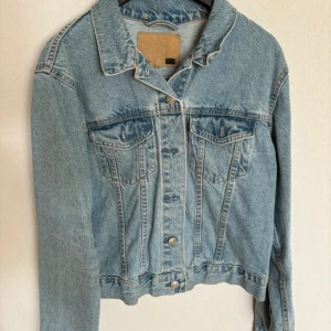 Ljusblå jeansjacka - Säljer en klassisk ljusblå jeansjacka i bra skick. Den har en normal passform med långa ärmar och knappar framtill. Perfekt för vår och sommar, och funkar lika bra till vardags som till fest. Ett måste i garderoben för en avslappnad stil! 💙