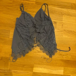 Grå/blå Urban Outfitters linne med knytning - Jättesött linne från Urban outfiters. Aldrig använt!🫶