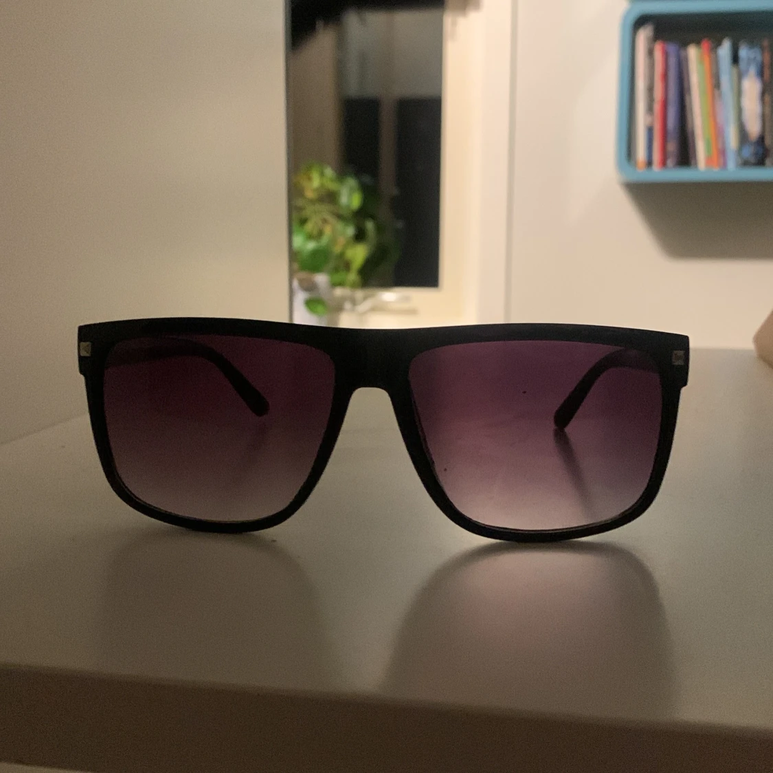 Svarta solglasögon med lila tonade linser