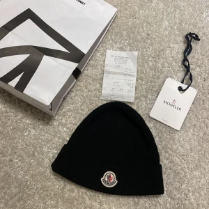 Moncler mössa ( KVITTO🧾 ) - Säljer en snygg svart stickad mössa från Moncler i nytt skick MED KVITTO. den är enligt mig den snyggaste moncler mössan och bekvämaste. Det finns etikett och kvitto kvar! inga deffekter på mössan, mvh 101 store🙌🏼