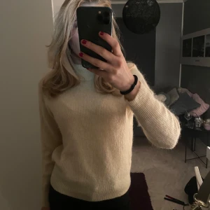 Vit stickad polotröja - Mysig beige stickad polotröja perfekt för kyliga dagar. Den har en klassisk design med långa ärmar och en bekväm passform. Perfekt för både vardag och mysiga hemmakvällar. ✨