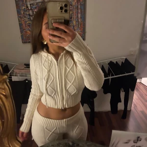 Vit stickad hoodie och byxor från Edikted - Säljer ett supermysigt set från Edikted i vitt. Hoodien är croppad med dragkedja och har långa ärmar. Byxorna är i samma stickade material och har en skön passform. Perfekt för höst och vinter Storlek M, ORIGINALPRIS 2800