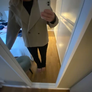 Beige kappa från Vila - Säljer en snygg beige kappa från Vila i storlek M. Den har en klassisk design med dubbelknäppning och breda slag. Perfekt för höst och vår! 🧥