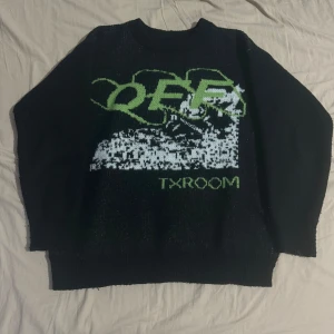 OFF WHITE svart stickad tröja. - Säljer en svart tröja med cool grön text och mönster på framsidan. Perfekt för en avslappnad stil. Tröjan har  ärmar och är i bra skick. Passar perfekt till höst och vinter. Passar som L, baggy fit.