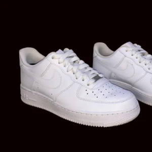 Vita Nike Air Force sneakers - Säljer ett par klassiska vita Nike Air Force sneakers i skinn. De har en stilren design med snörning och perforerade detaljer på tån för extra ventilation. Perfekta för både vardag och fest! 🏀👟| äkta skor | box medföljer ej | vid fler frågor så är det bara att skriva😃👍
