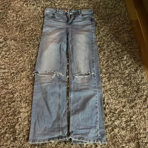 Blå jeans med slitningar - Säljer ett par coola blå jeans från LAB Industries i storlek 164. De har en avslappnad passform med slitningar på knäna för en trendig look. Perfekta för en casual stil och passar bra till både sneakers och kängor. Jeansens material är hållbart och bekvämt.❤️