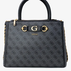 Svart handväska från Guess - Snygg svart handväska från Guess med gulddetaljer och ett diskret mönster. Väskan har en praktisk dragkedja och kedjedetaljer på sidorna. Perfekt för både vardag och fest!