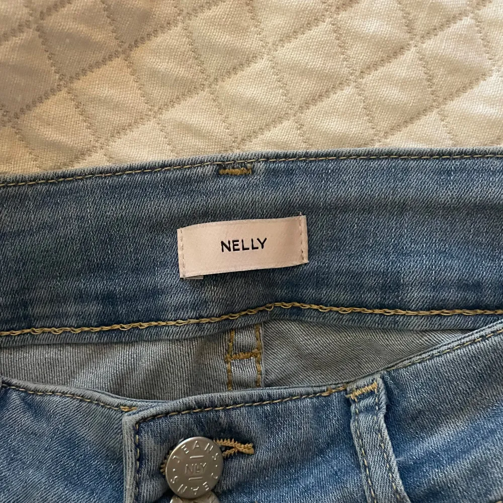 Säljer ett par snygga blå jeans från Nelly. De  är Bootcut, har slitningar på knäna och har använts ett få tal gånger💛 . Jeans & Byxor.