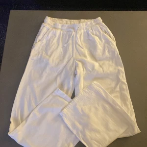 Vita mjukisbyxor - Säljer ett par superbekväma vita mjukisbyxor. Perfekta för en chill dag hemma eller en avslappnad promenad. De har en elastisk midja och är gjorda i ett mjukt material som känns skönt mot huden. Passar perfekt för både vår och sommar!