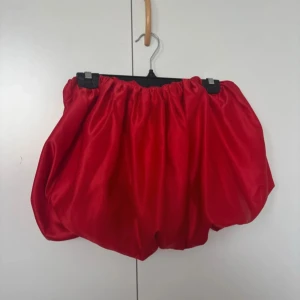 Röd ballongkjol - Säljer en superfin röd ballongkjol i glansigt material. Den har en elastisk midja för bekväm passform och en unik ballongform som ger volym. Från SHEIN, helt ny aldrig använd endast på testad. Original pris 150kr