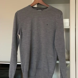 Grå tröja från J.Lindeberg - Säljer en stilren grå tröja från J.Lindeberg i storlek S. Tröjan är i mycket bra skick och har en liten logga på bröstet. Perfekt för både vardag och lite finare tillfällen. Den är långärmad och har ribbade muddar vid ärmslut och nederkant. Passar perfekt till vinter. Köpt för 1600 säljer för 600