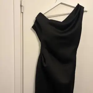 Elegant svart one-shoulder klänning. Aldrig använd prislapp kvar