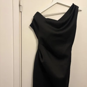 Svart one-shoulder klänning - Elegant svart one-shoulder klänning. Aldrig använd prislapp kvar