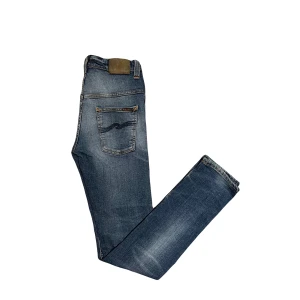 Nudie jeans - Nudie jeans med snygg wash! Modell tape ted. Storlek 29/34. En liten skråma på höger ficka!