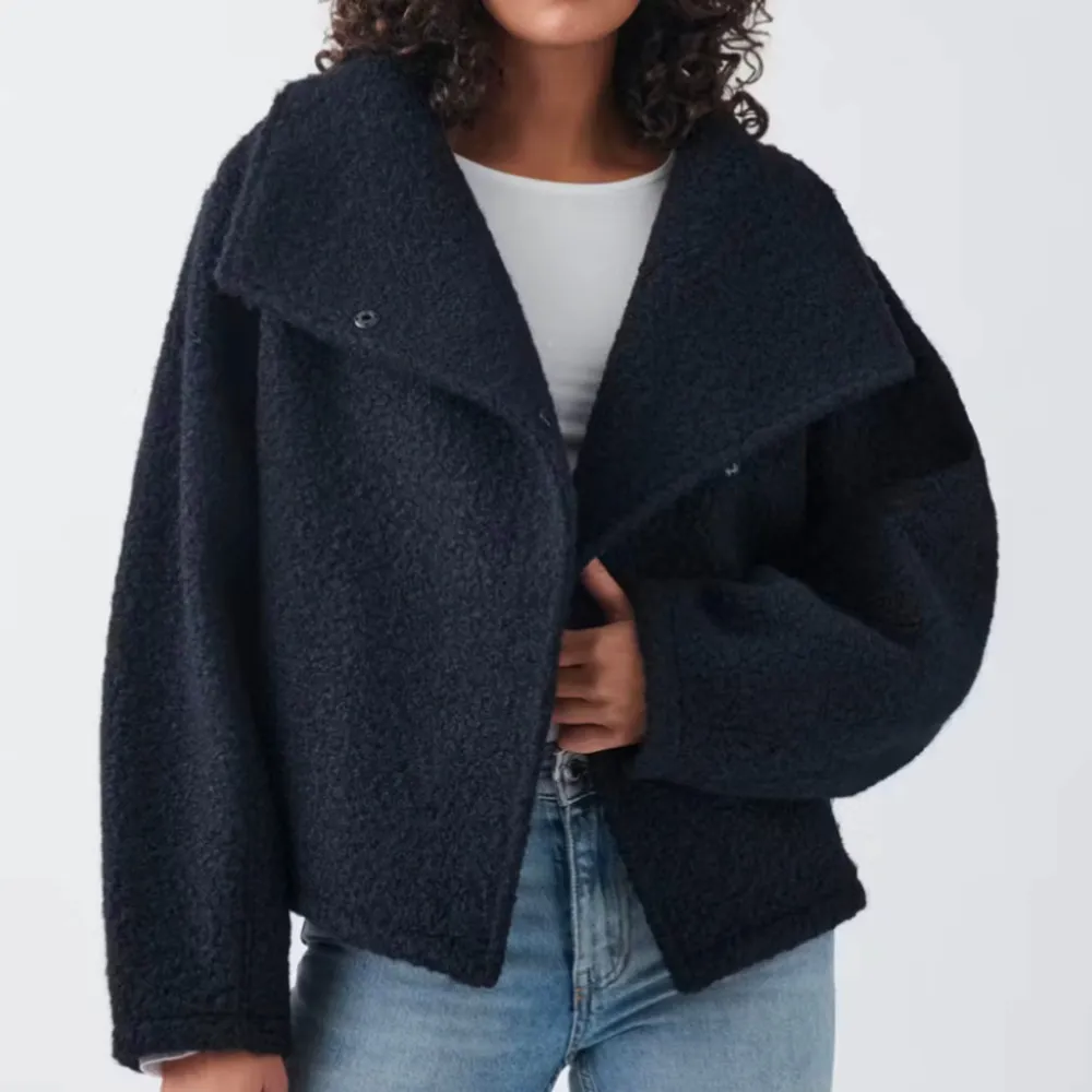 Mysig marinblå teddyjacka i oversized stil. Perfekt för höst och vinter med sin varma och fluffiga känsla. Jackan har långa ärmar och en unik design med en stor krage. Den är både trendig och bekväm, idealisk för kalla dagar.. Jackor.