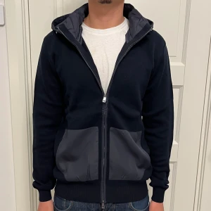 Cardigan/ jacka - Otroligt fet cardigan! Sprillans ny och oanvänd med lapparna kvar. Avtagbar dunluva, vilket gör att den passar till olika tillfällen. Storlek M. Nypris ca. 1700kr.  Hör av dig vid frågor/funderingar  