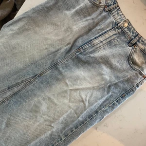 Jeanskjol från Stradivarius - Säljer en snygg jeanskjol från Stradivarius i storlek 40. Kjolen har en klassisk blå jeansfärg och är perfekt för både vardag och fest. Den har en normal passform och är gjord i ett slitstarkt denimtyg. Perfekt för att matcha med en t-shirt eller en stickad tröja!