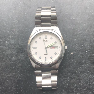 Seiko Quartz deluxe  - Fin vintage aktig klocka med en tidlös och elegant daydate complication, har några repor på armbandet och glaset men tickar och håller tiden bra.