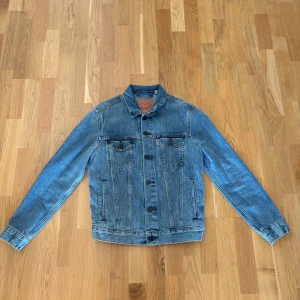 Jeansjacka från Levi Strauss & Co. - Säljer en klassisk jeansjacka från Levi Strauss & Co. i blå denim. Jackan har en tidlös design med knappar framtill och två bröstfickor med knappstängning. Perfekt för vår och höst!