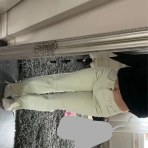 Beige jeans med fransar - Säljer ett par snygga väldigt ljusgröna raka jeans med mid waist. De har en slits och cool fransdetalj vid bensluten som ger en avslappnad look. Perfekta för både vardag och fest!