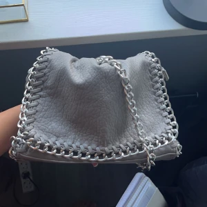 Beige/grå tiamo väska - I perfekt skick, ingen rost eller deffekter, ej smutsig inuti och kedjan är låbg sp man kan ha den som jag har på bilden eller crossbody🫶🏻🤍
