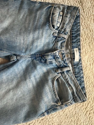 Ljusblå raka low waist jeans från Gina Tricot - Säljer Ljusblå lågmidjade jeans från Gina Tricot med klassisk femficksmodell och raka ben. Jeansen är tillverkade i denim och är perfekta för en avslappnad och trendig stil. Har används 1 gång och säljs då de inte kommit till användning, pris kan diskuteras och det är ink frakt. Storlek:34. Kontakta för mer information 🌸