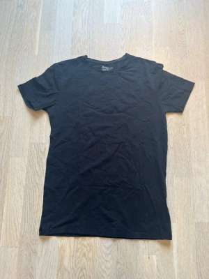 Svart basic t-shirt från Basic You - En enkel svart t-shirt från Basic You i ekologisk bomull. Klassisk rund halsringning och korta ärmar. Perfekt till alla outfits och superbekväm tack vare det mjuka materialet. Tveka inte på att skriva en fråga eller be om fler bilder.🌸🌸