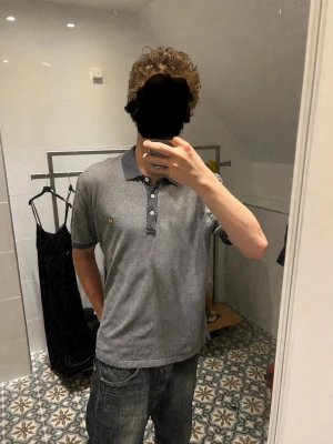 Grå pikétröja från Lyle & Scott - Säljer en stilren och exklusiv pikétröja från Lyle & Scott i en snygg blå färg med broderad logga på bröstet.  * Storlek: L (passar mer som en M) * Skick: Nästan helt ny, använd väldigt få gånger * 100 % original * Perfekt till både vardag och mer uppklädda tillfällen  En kvalitetsklassiker från ett premiumvarumärke som håller länge. Säljs eftersom den inte kommer till användning.  📦 Snabb frakt 💬 Hör gärna av dig vid frågor eller om du vill ha fler bilder!