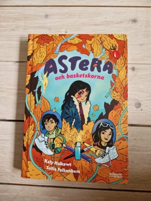 Astera och basketskorna - Boken handlar om Astera och hennes vardag, vänskap och basket. Skriven av Kaly Halkawt och illustrerad av Sofia Falkenhem. Utgiven av Bonnier Carlsen.