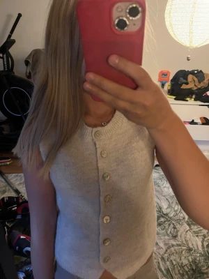 Beige stickad väst från Gina Tricot💕 - Säljer en beige stickad väst från Gina Tricot med rund halsringning och knappar framtill, Västen är ärmlös🩷