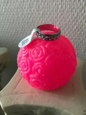 Anti Stress ring - Säljer en stilren silverfärgad anti stress ring med ett upphöjt stjärnmönster runt hela bandet. Ringen har en klassisk, rund form och passar perfekt för dig som gillar detaljerade accessoarer. Finns stlk 17-21 kvar , samma frakt 