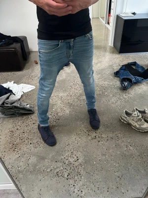  slim fit jeans tiger of Sweden  - Modellen på bilden är 180cm lång och väger ca 62kg. De är för små för mig. Säljer ett par ljusblå slim fit jeans med klassisk femficksdesign och dragkedjegylf. Jeansen har en smal passform och sitter tight längs benen, perfekta för en modern och avslappnad stil. Materialet är mjukt denim som ger bra komfort.