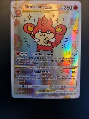 Pokémonkort Simisear VSTAR - Unikt Pokémonkort med Simisear VSTAR-motiv. Kortet har en holografisk yta med färger i rött, gult och silver. Text och illustrationer är tryckta på klassiskt Pokémonkort-material. Perfekt för samlare eller Pokémonfans.