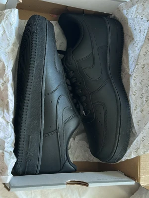 Helsvarta låga sneakers i läder - Snygga helsvarta sneakers i klassisk modell med lågt skaft. Tillverkade i slätt läder med matchande svarta skosnören och sula. Diskret design med perforeringar på tån för extra ventilation och stilrena detaljer på sidan. Helt oanvända. Säljer pågrund av att dom aldrig kommer till användning