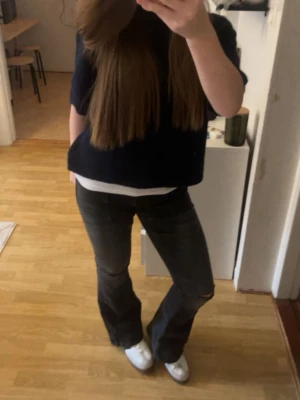 Svarta bootcut jeans med slitning - Säljer ett par svarta bootcut jeans med lätt slitning vid knät. Jeansen har en klassisk femficksmodell och är i stretchigt material för skön passform. Perfekta till sneakers eller boots för en avslappnad look.