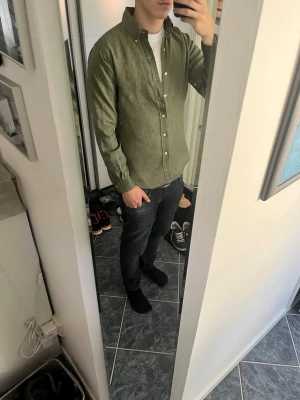 Olivgrön skjorta från Ralph Lauren - Säljer en riktigt fet olivgrön linneskjorta från polo Ralph lauren, skjortan är lite solblekt men ser fortfarande extremt bra ut. Skjortan är i storlek S men funkar även för dem flesta med M säljer för 450 men priset är inte hugget i sten. Ingen retur