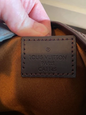 Louis Vuitton Neverfull PM Damier Ebene - Säljer en Louis Vuitton Darian PM axelväska i klassiska Damier Ebene-mönstret. Väskan har brunt canvasmaterial med mörkbruna läderdetaljer och guldiga metalldetaljer. Perfekt storlek för vardagsbruk och rymmer det viktigaste. Väldigt fin men inte min stil. En gåva på min 40års dag. Dustbag och kvitto finns. 