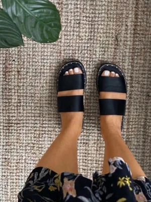 Svarta sandaler från Zara  - Säljer ett par svarta sandaler från Zara  med två breda remmar över foten och dekorativa nitar runt sulan. Sandalerna har en platt sula och är tillverkade i konstläder. Perfekta för en avslappnad och trendig look.